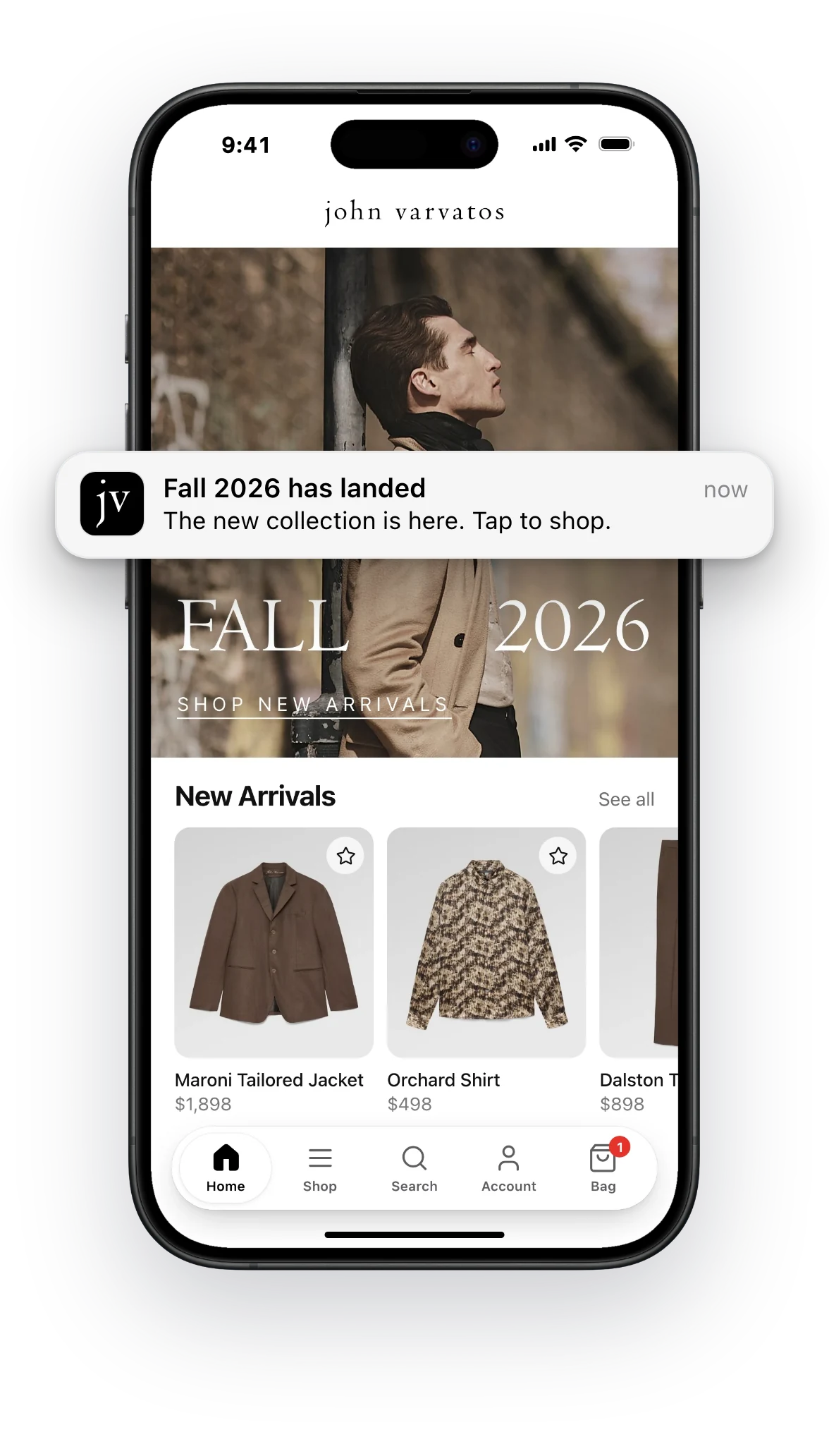 A John Varvatos app home screen on an iPhone, with the wordmark at the top, the Fall 2026 campaign, a New Arrivals row of jackets and shirts with prices, and a floating tab bar for Home, Shop, Search, Account and Bag, plus a push notification announcing the new collection